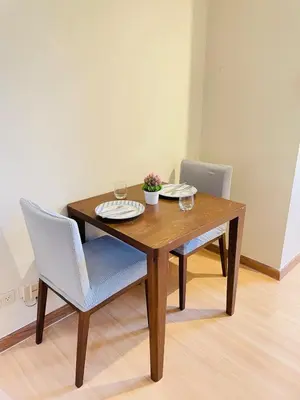 a wooden table and two chairs with wine glasses on it at Designer Pad Town with Free Pool, Gym and Smart TV and Fast Wifi in Manila