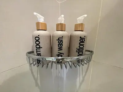 three shampoo bottles in a glass holder in a bathroom at Designer Pad Town with Free Pool, Gym and Smart TV and Fast Wifi in Manila
