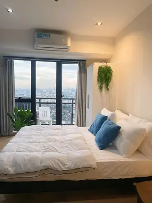 a bedroom with a large bed with a large window at Designer Pad Town with Free Pool, Gym and Smart TV and Fast Wifi in Manila