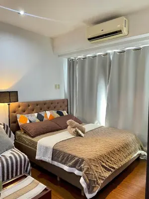 a bedroom with a bed and a window at Poblacion Makati with Pool, Gym, Jacuzzi, Pool Table and fast wifi in Manila