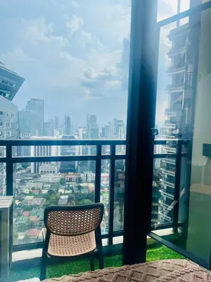 a chair on a balcony with a view of a city at Poblacion Makati with Pool, Gym, Jacuzzi, Pool Table and fast wifi in Manila