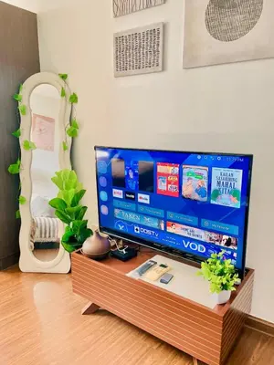 a flat screen tv sitting on top of a wooden table at Poblacion Makati with Pool, Gym, Jacuzzi, Pool Table and fast wifi in Manila