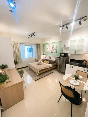 a large living room with a bed and a kitchen at Venice McKinley Stay with Pool, Gym, fast Wifi and Netflix in Manila