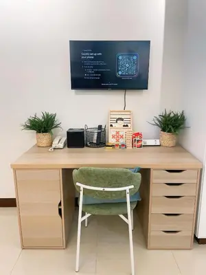 a desk with a chair and a monitor on a wall at Venice McKinley Stay with Pool, Gym, fast Wifi and Netflix in Manila