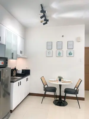 a kitchen with a table and two chairs in it at Venice McKinley Stay with Pool, Gym, fast Wifi and Netflix in Manila