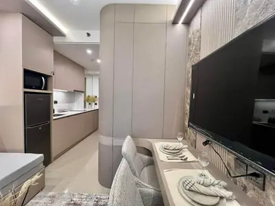 a living room with a large television and a kitchen at Harbor Calm Suite in Manila