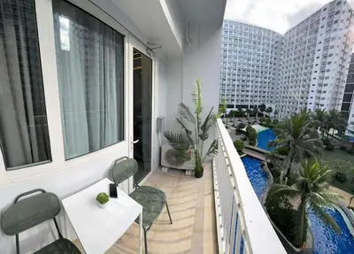 a balcony with a table and chairs and a pool at Harbor Calm Suite in Manila