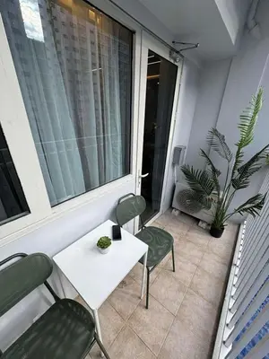 a balcony with a table and chairs and a plant at Harbor Calm Suite in Manila