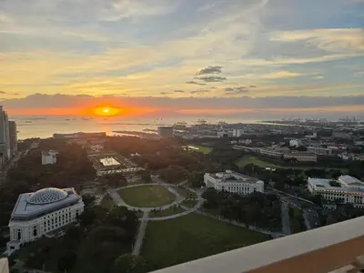 a view of a city with the sunset in the background at The Sunset Suite at Torre 3916 in Manila