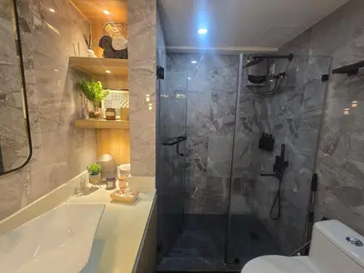 a bathroom with a shower and a tub and a sink at The Sunset Suite at Torre 3916 in Manila