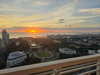 a view of the sunset from a balcony of a building at The Sunset Suite at Torre 3916 in Manila
