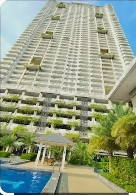 a large white building with a pool in front of it at The Sunset Suite at Torre 3916 in Manila