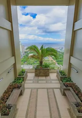 a balcony with a palm tree in a building at The Sunset Suite at Torre 3916 in Manila