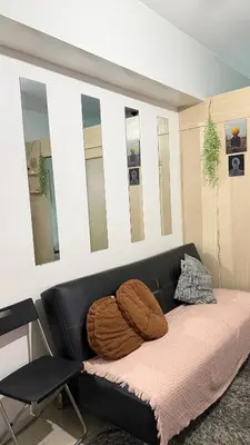 a black couch in a room with mirrors at Jazz staycation makati by as in Manila