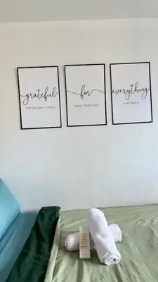 four pictures on a wall above a bed with towels at Jazz staycation makati by as in Manila