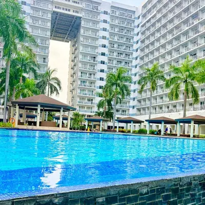 a large swimming pool in front of tall buildings at A&K Staycations by Shell Residences MOA in Manila