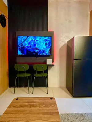 a living room with a television and a table and chairs at A&K Staycations by Shell Residences MOA in Manila