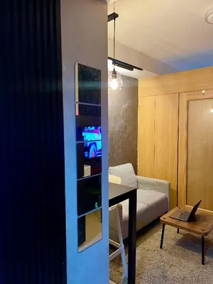 a living room with a table with a laptop on it at A&K Staycations by Shell Residences MOA in Manila