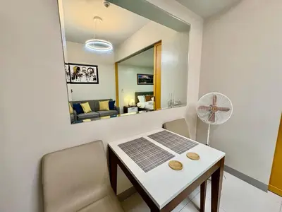 a small room with a table and chairs and a mirror at Uptown Home 1BR at One Uptown Residence BGC in Manila