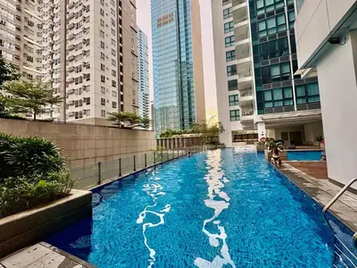 a swimming pool in the middle of a building with tall buildings at Uptown Home 1BR at One Uptown Residence BGC in Manila