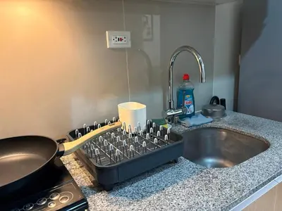 a kitchen counter with a sink next to a sink at Uptown Home 1BR at One Uptown Residence BGC in Manila