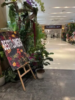 a chair sitting in the middle of a mall with plants at Uptown Home 1BR at One Uptown Residence BGC in Manila