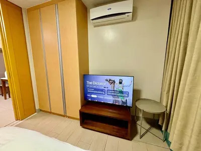 a bedroom with a flat screen tv in a room at Uptown Home 1BR at One Uptown Residence BGC in Manila