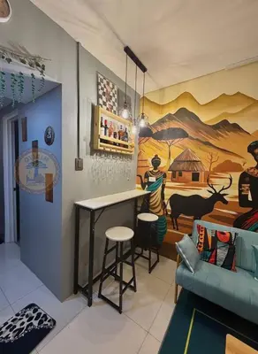 a bar in a room with a painting on the wall at Cozy African Themed Unit in Parañaque in Manila