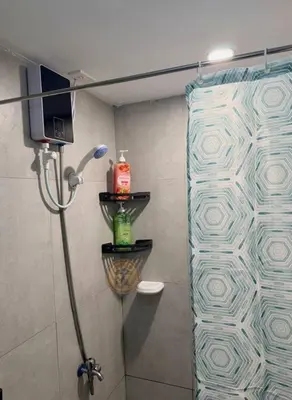 a shower with a glass door in a bathroom at Cozy African Themed Unit in Parañaque in Manila
