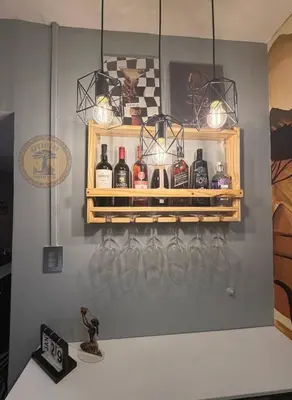 a shelf with wine glasses on a wall at Cozy African Themed Unit in Parañaque in Manila