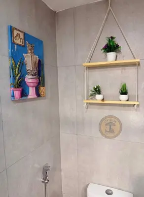 a bathroom with potted plants on shelves above a toilet at Cozy African Themed Unit in Parañaque in Manila