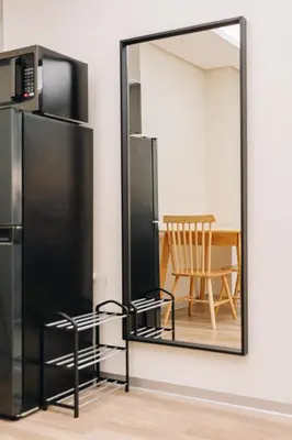 a mirror in a room with a table and a chair at Dragon's Keep BNB near NAIA and MOA in Manila