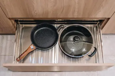 a frying pan and a strainer sitting in a drawer at Dragon's Keep BNB near NAIA and MOA in Manila