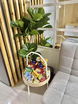 a table with chips and a plant next to a chair at Hidden All in Comfy Luxe Stay MOA Pasay in Manila