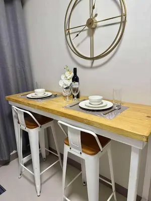 a dining table with two chairs and a clock on the wall at Hidden All in Comfy Luxe Stay MOA Pasay in Manila