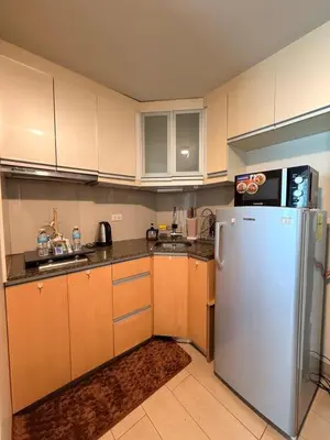 a kitchen with wooden cabinets and a white refrigerator at Kai cabins NEAR NAIA 3 SELF CHECK IN AT NEWPORT CITY in Manila
