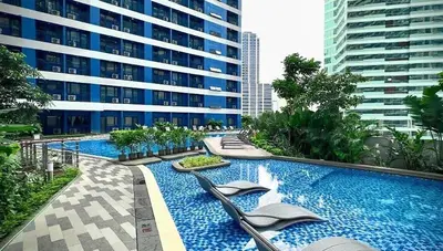 a large swimming pool with chairs in a building at Makati Staycation by Jing in Manila