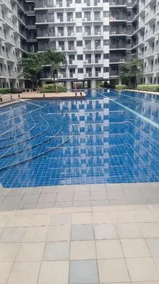 a large blue swimming pool in a building at R&A staycation in Manila