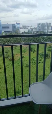 a balcony with a white chair and a green field at R&A staycation in Manila