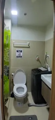 a bathroom with a toilet and a sink at R&A staycation in Manila