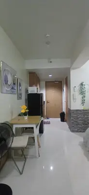 a living room with a table and a kitchen at R&A staycation in Manila