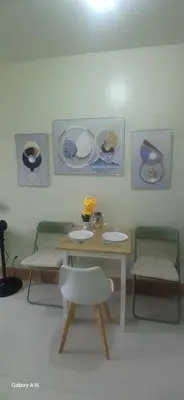 a room with a table and two chairs and a table with sinks at R&A staycation in Manila
