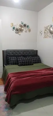 a bedroom with a bed with a ceiling fan at R&A staycation in Manila