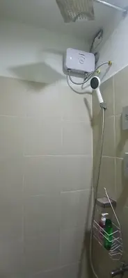 a bathroom with a blow dryer on the wall at R&A staycation in Manila