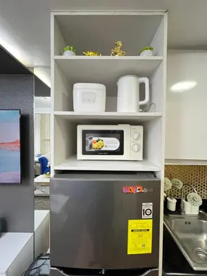 a microwave on top of a refrigerator in a kitchen at Shore 2 Near MOA Arena IKEA Okada in Manila