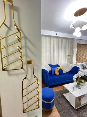 a living room with a blue couch and a gold shelf at Shore 2 Near MOA Arena IKEA Okada in Manila