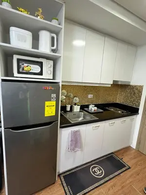 a kitchen with a refrigerator and a sink at Shore 2 Near MOA Arena IKEA Okada in Manila