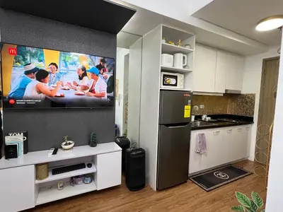 a kitchen with a flat screen tv on the wall at Shore 2 Near MOA Arena IKEA Okada in Manila