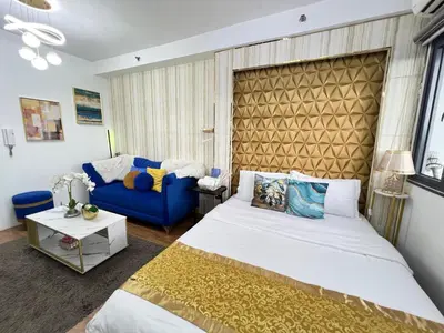 a bedroom with a bed and a blue couch at Shore 2 Near MOA Arena IKEA Okada in Manila