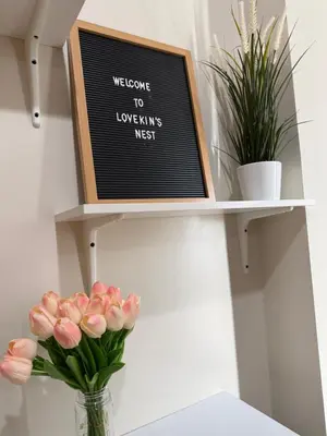 a shelf with a sign and flowers in a vase at Lovekin's Nest at The Verdin in General Trias